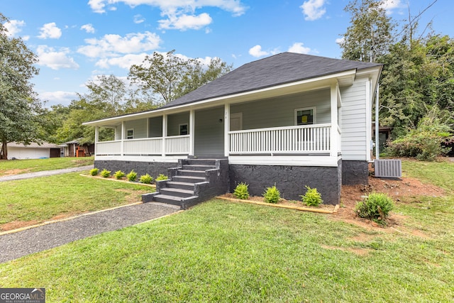 view of front of house featuring a front lawn, covered porch, and central AC unit