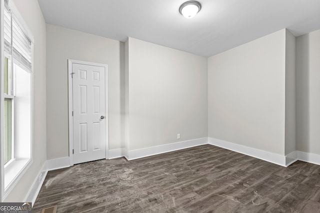 unfurnished room with dark hardwood / wood-style flooring