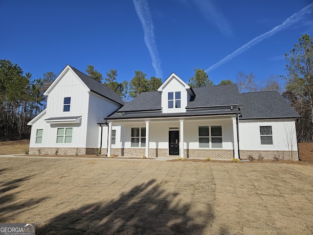 modern inspired farmhouse featuring a front lawn and a porch