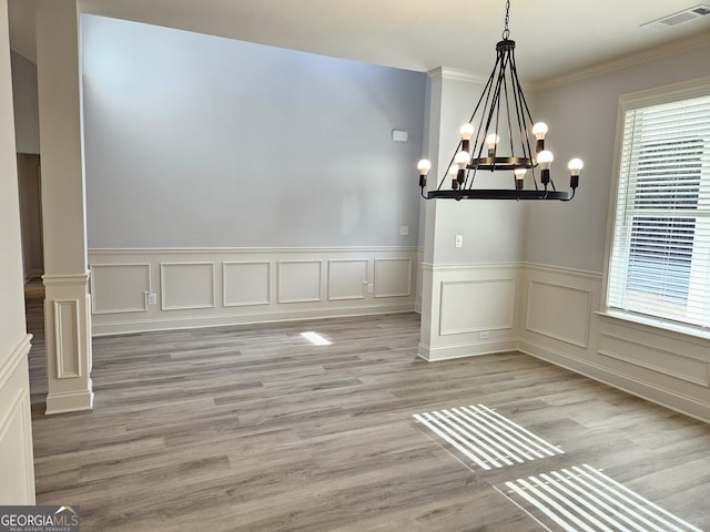 unfurnished dining area featuring a wealth of natural light, light hardwood / wood-style floors, and a notable chandelier