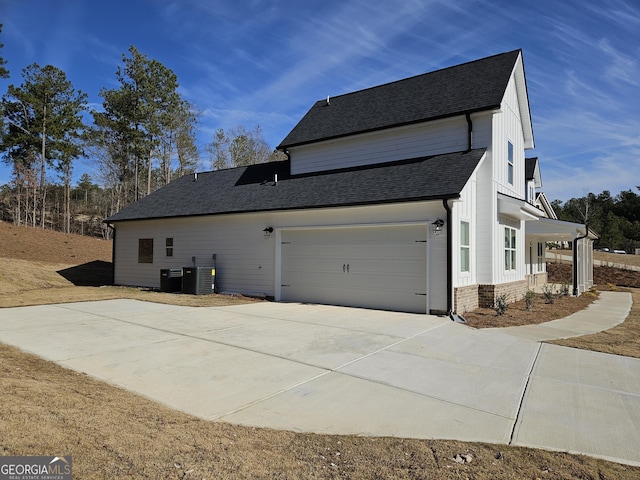 view of side of property featuring central air condition unit and a garage