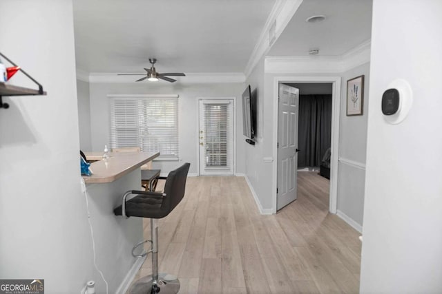 unfurnished office featuring ornamental molding, light wood-type flooring, and ceiling fan