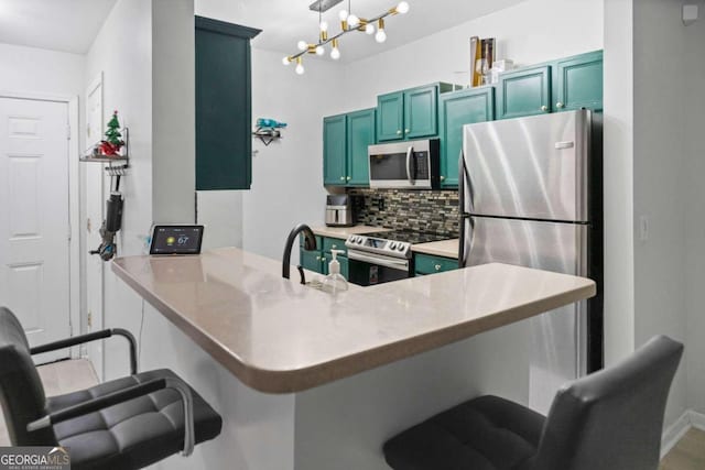 kitchen featuring a kitchen breakfast bar, stainless steel appliances, kitchen peninsula, and tasteful backsplash