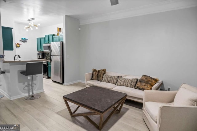 2700 Pine St NE Unit 2108, Atlanta, GA 30324 - living room featuring light wood-style flooring, a chandelier, ornamental molding, and baseboards
