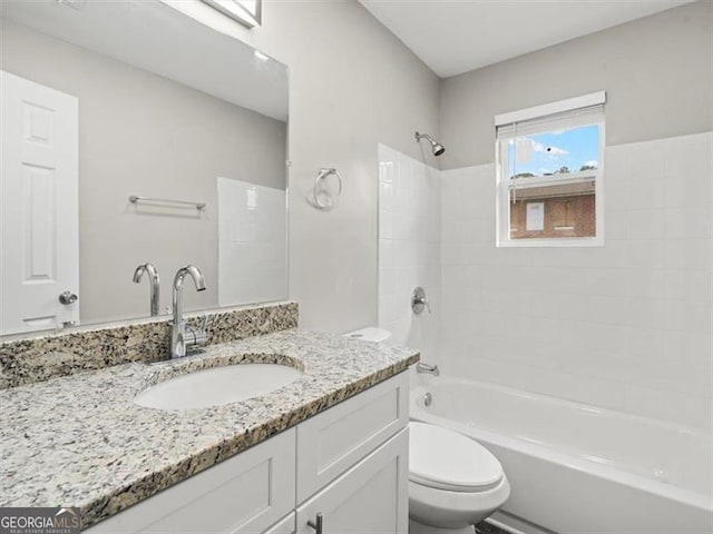 full bathroom with tiled shower / bath combo, vanity, and toilet