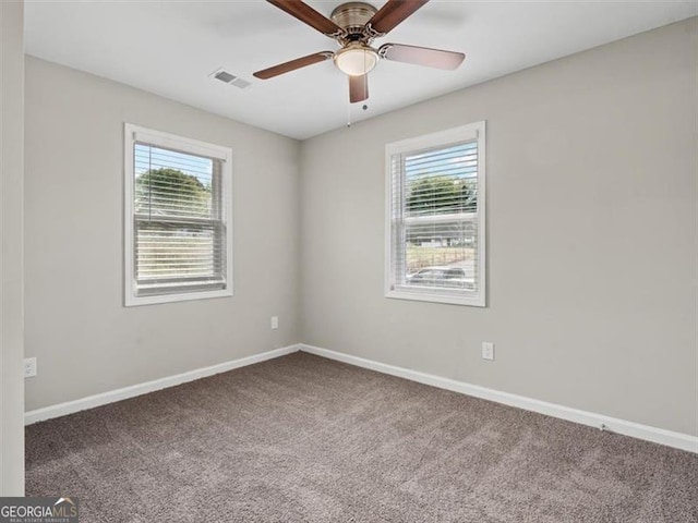 carpeted empty room with a healthy amount of sunlight and ceiling fan