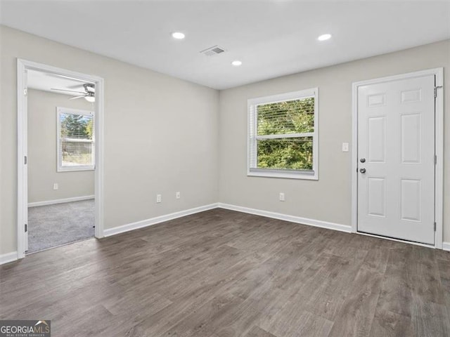 empty room with ceiling fan and dark hardwood / wood-style flooring