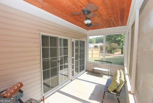 unfurnished sunroom with wood ceiling and ceiling fan