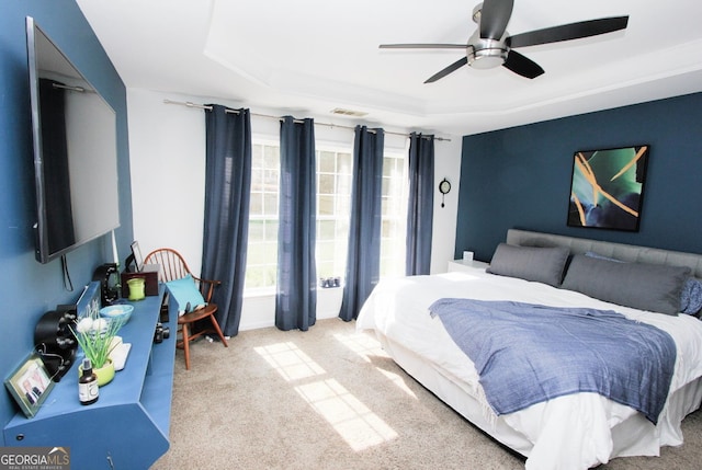 bedroom featuring a tray ceiling, ceiling fan, and light colored carpet