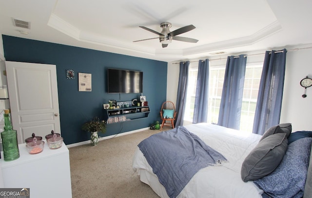 bedroom with a raised ceiling, ceiling fan, and light colored carpet