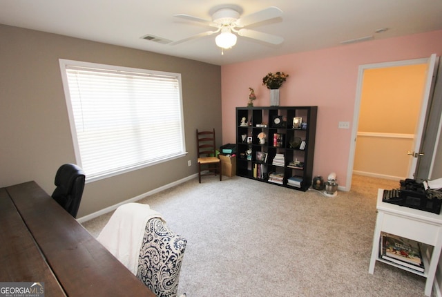 carpeted home office featuring ceiling fan