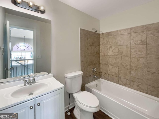 full bathroom featuring wood-type flooring, tiled shower / bath, vanity, and toilet