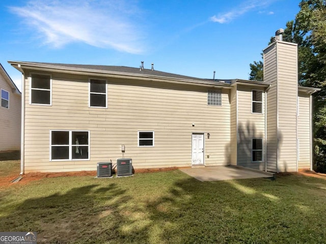 rear view of house featuring central AC unit, a lawn, and a patio area