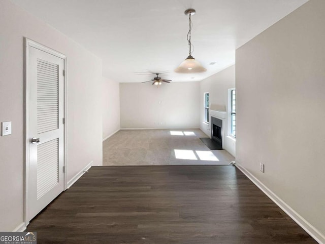 unfurnished living room with dark wood-type flooring and ceiling fan