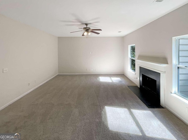 unfurnished living room featuring ceiling fan and carpet flooring