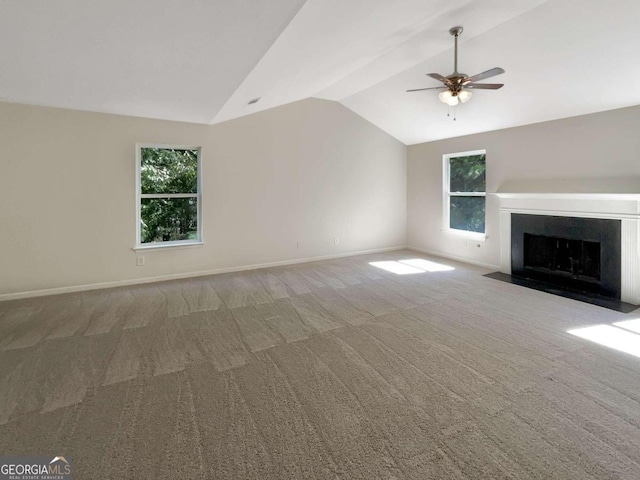 unfurnished living room featuring ceiling fan, lofted ceiling, plenty of natural light, and carpet flooring