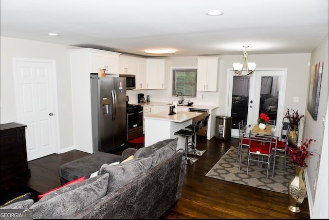 kitchen featuring appliances with stainless steel finishes, a center island, dark hardwood / wood-style floors, and white cabinets