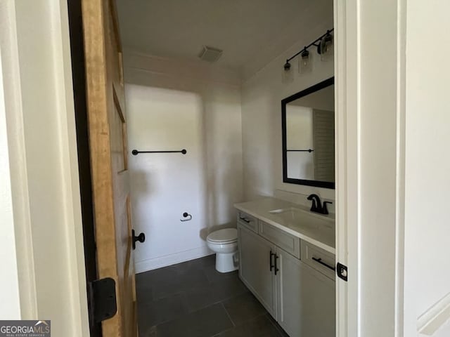 bathroom featuring vanity, toilet, and tile patterned floors