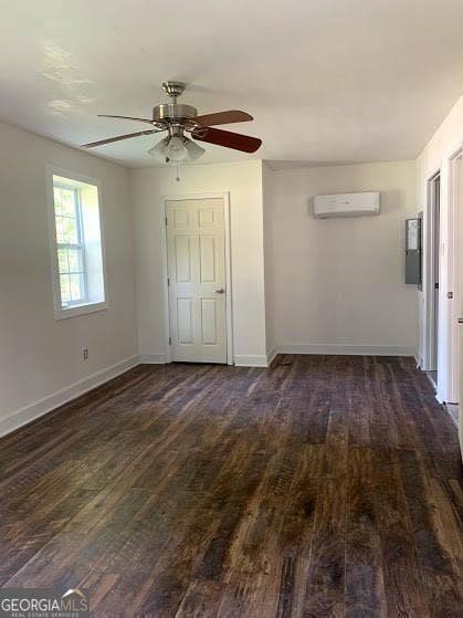 empty room with a wall mounted air conditioner, dark hardwood / wood-style floors, and ceiling fan