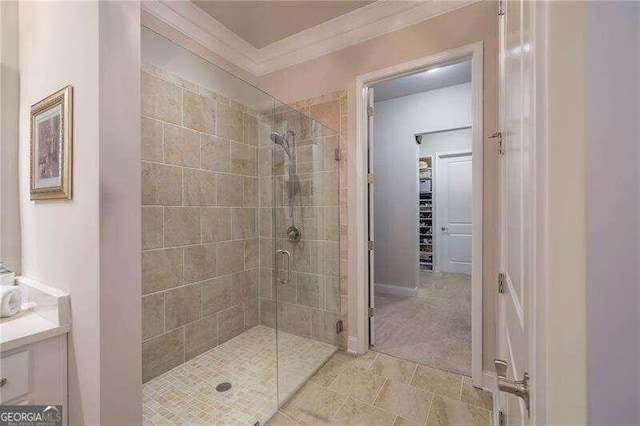 bathroom with ornamental molding, vanity, and a shower with shower door