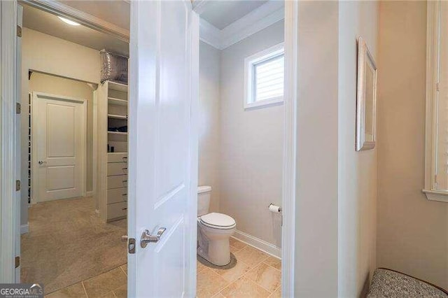 bathroom featuring crown molding and toilet