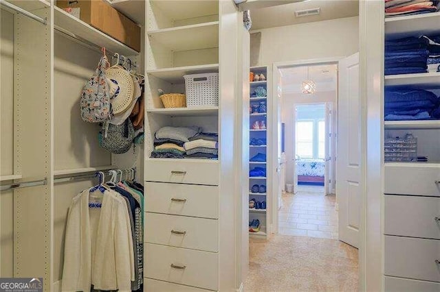 walk in closet with light tile patterned floors