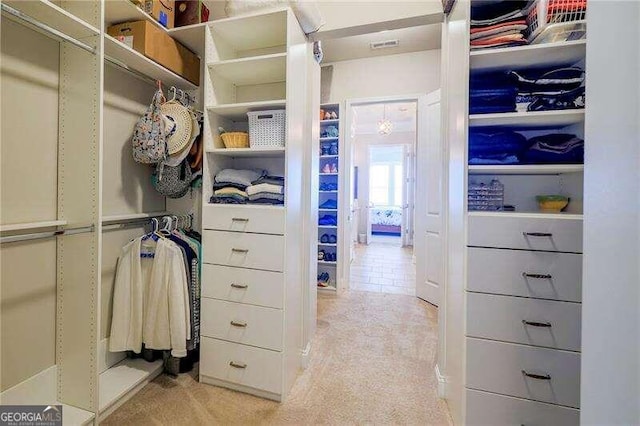 walk in closet featuring light colored carpet