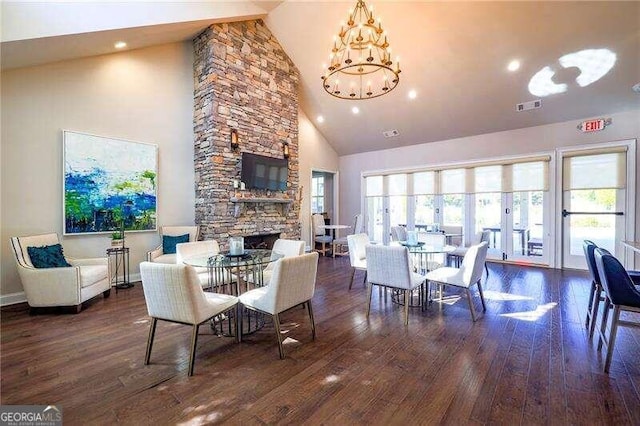 dining area with a fireplace, plenty of natural light, dark hardwood / wood-style floors, and high vaulted ceiling