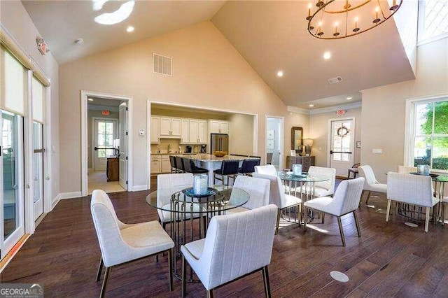 dining area featuring an inviting chandelier, dark hardwood / wood-style floors, and high vaulted ceiling