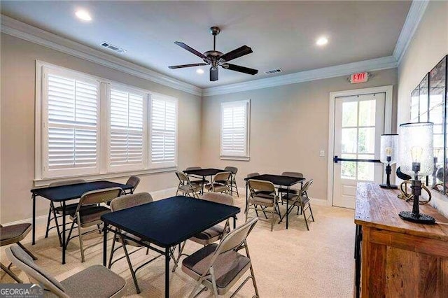 dining room with ceiling fan, light colored carpet, plenty of natural light, and crown molding