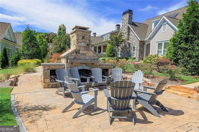 view of patio featuring an outdoor stone fireplace