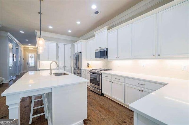 kitchen with white cabinets, appliances with stainless steel finishes, hanging light fixtures, and sink