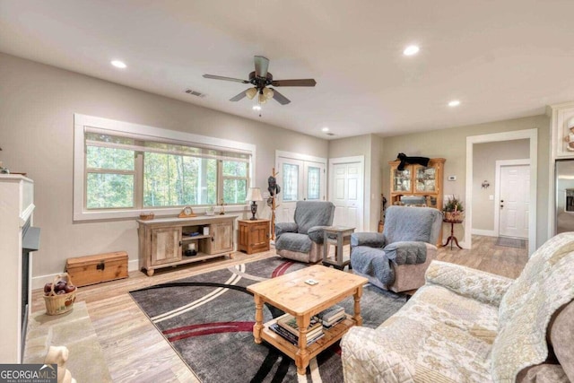 living room with light hardwood / wood-style floors and ceiling fan