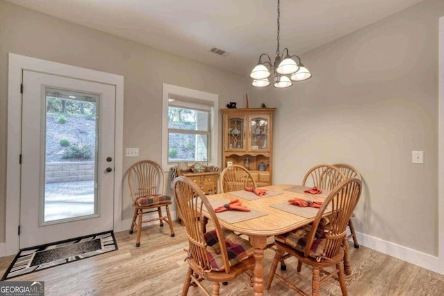 dining space featuring a notable chandelier and light hardwood / wood-style floors