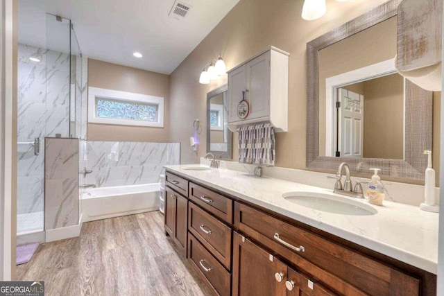 bathroom featuring shower with separate bathtub, hardwood / wood-style floors, and vanity