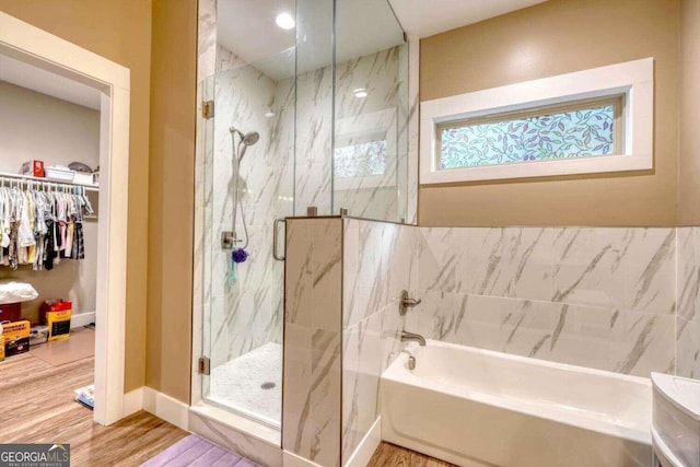 bathroom featuring wood-type flooring and shower with separate bathtub