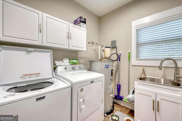 laundry room with sink, cabinets, washing machine and dryer, water heater, and light wood-type flooring