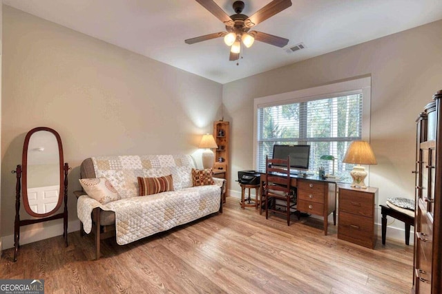 office with light wood-type flooring and ceiling fan