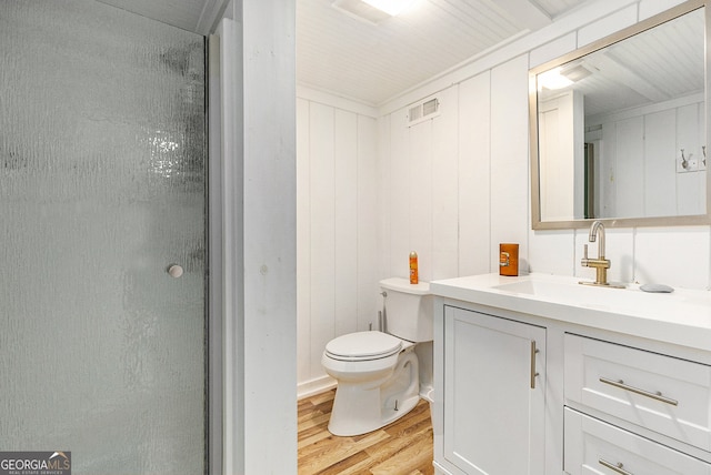 bathroom with a shower with door, hardwood / wood-style flooring, vanity, and toilet