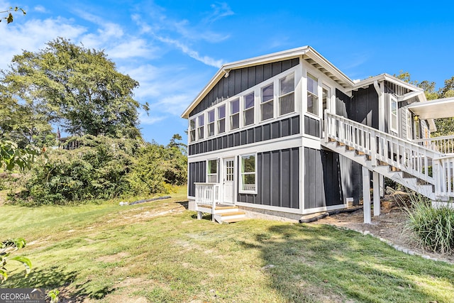 back of property featuring a lawn and a sunroom