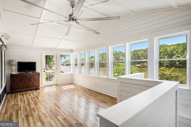 sunroom / solarium with a water view, vaulted ceiling, and ceiling fan