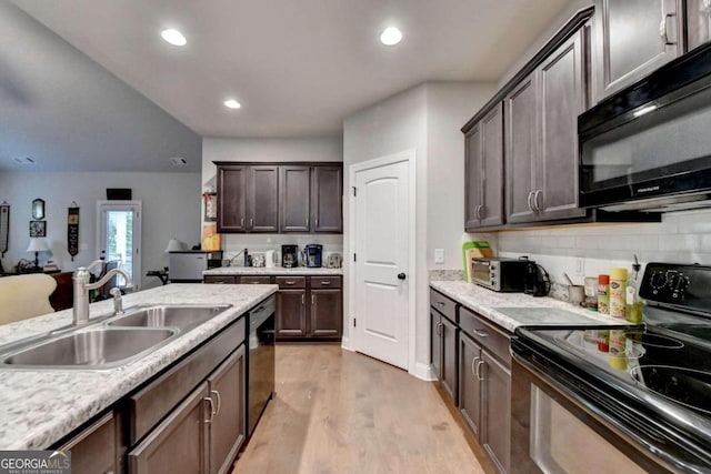 kitchen with dark brown cabinets, light wood-type flooring, tasteful backsplash, sink, and black appliances