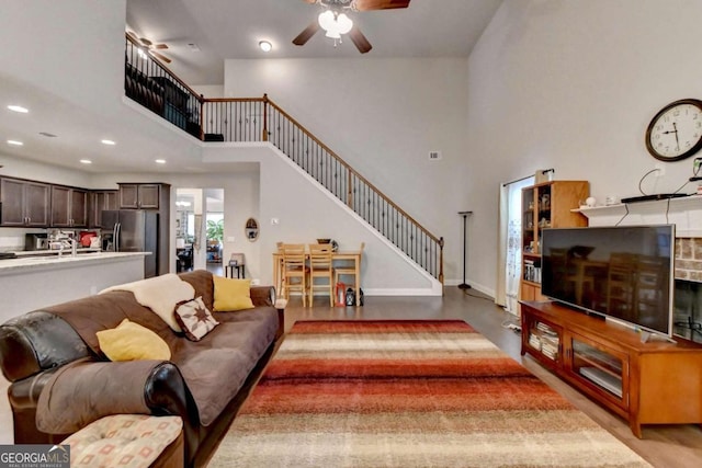 living room with a towering ceiling and ceiling fan