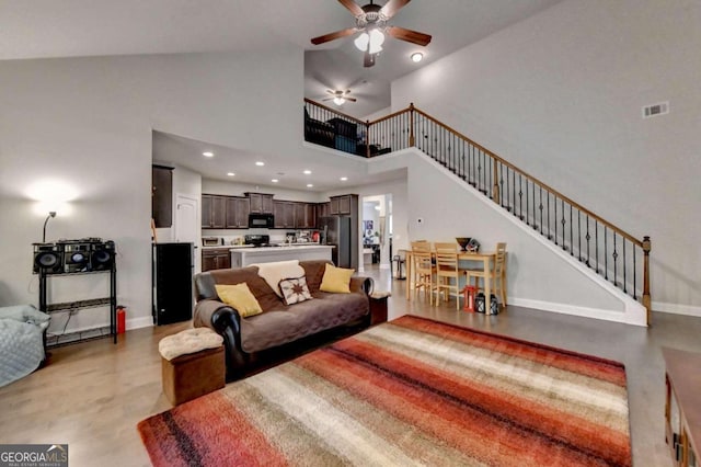 living room featuring ceiling fan and high vaulted ceiling