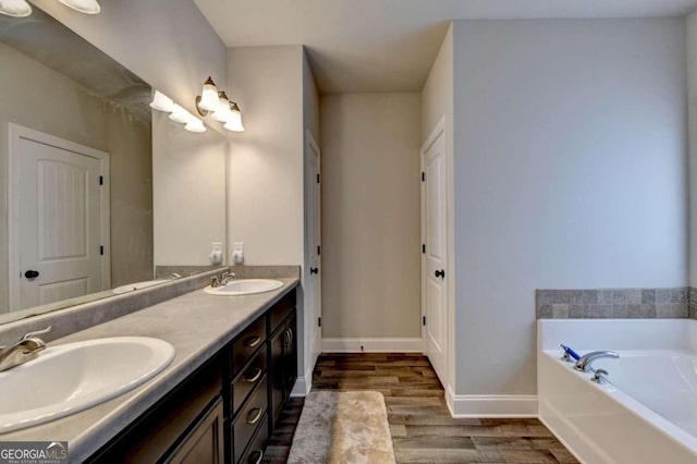 bathroom featuring wood-type flooring, vanity, and a washtub