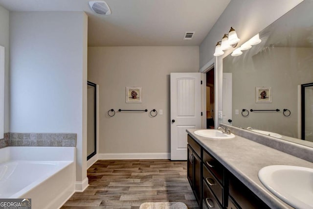 bathroom featuring vanity, hardwood / wood-style floors, and plus walk in shower