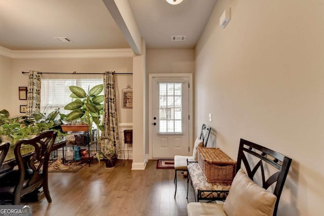 entryway with decorative columns, dark hardwood / wood-style floors, a healthy amount of sunlight, and crown molding