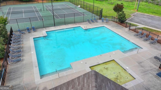 view of swimming pool featuring tennis court