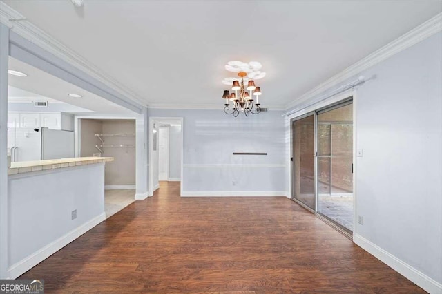 unfurnished living room featuring ceiling fan with notable chandelier, wood-type flooring, ornamental molding, and a brick fireplace