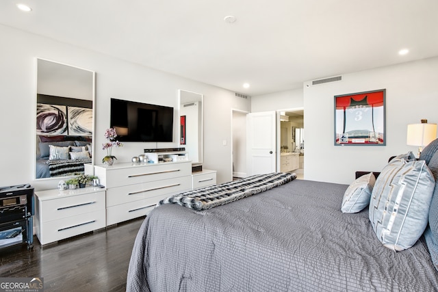 bedroom featuring ensuite bathroom and dark hardwood / wood-style floors